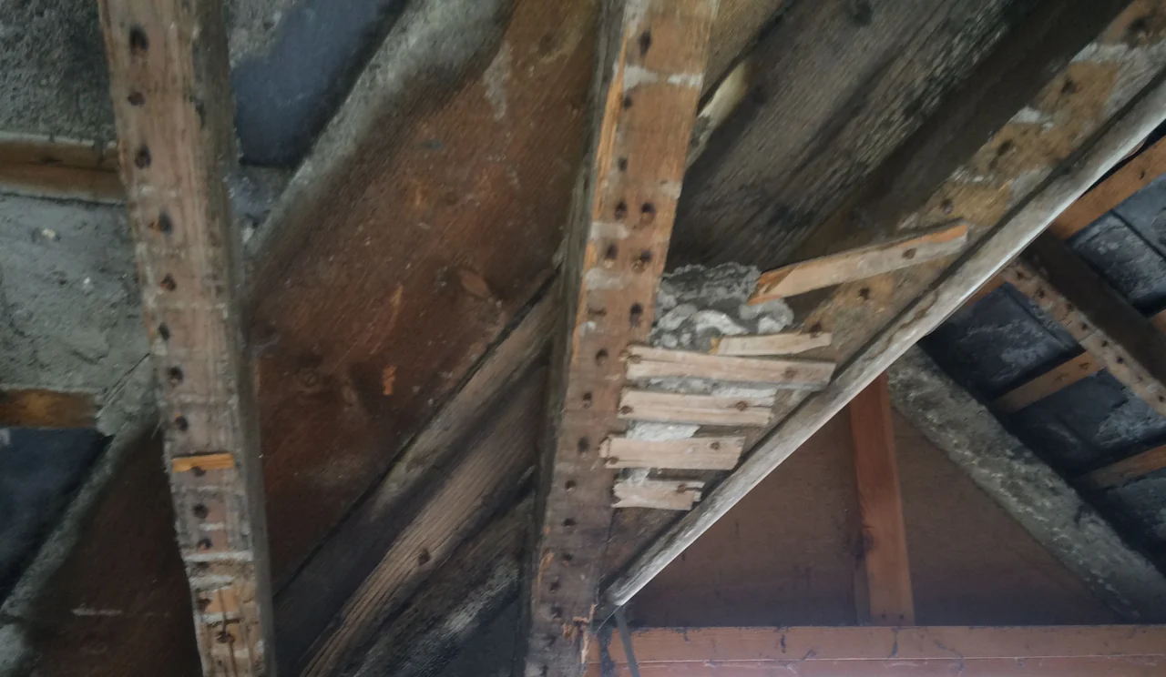Exposed roof valley timbers with staining and deterioration in Buxton