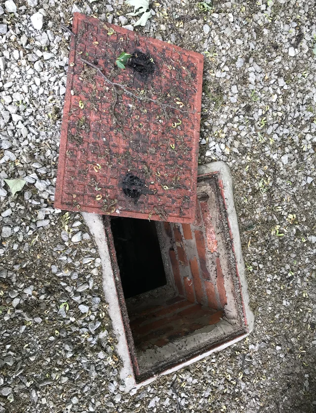 Lifted inspection cover above the private foul drainage chamber in Buxworth