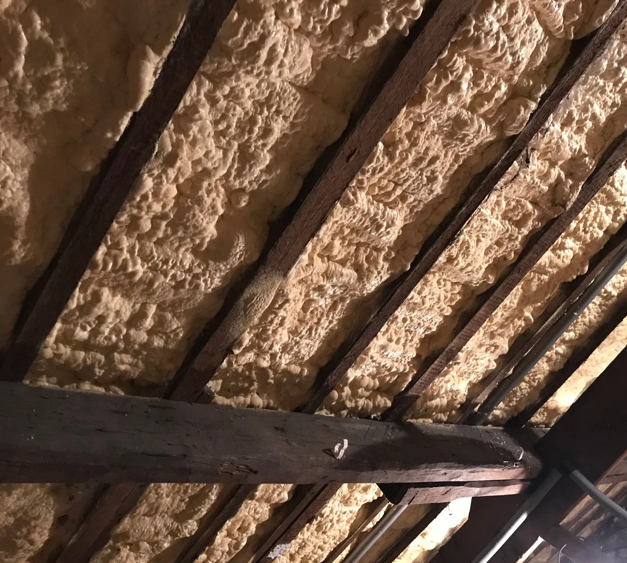 Spray foam applied between timber rafters beneath a traditional roof in Buxworth