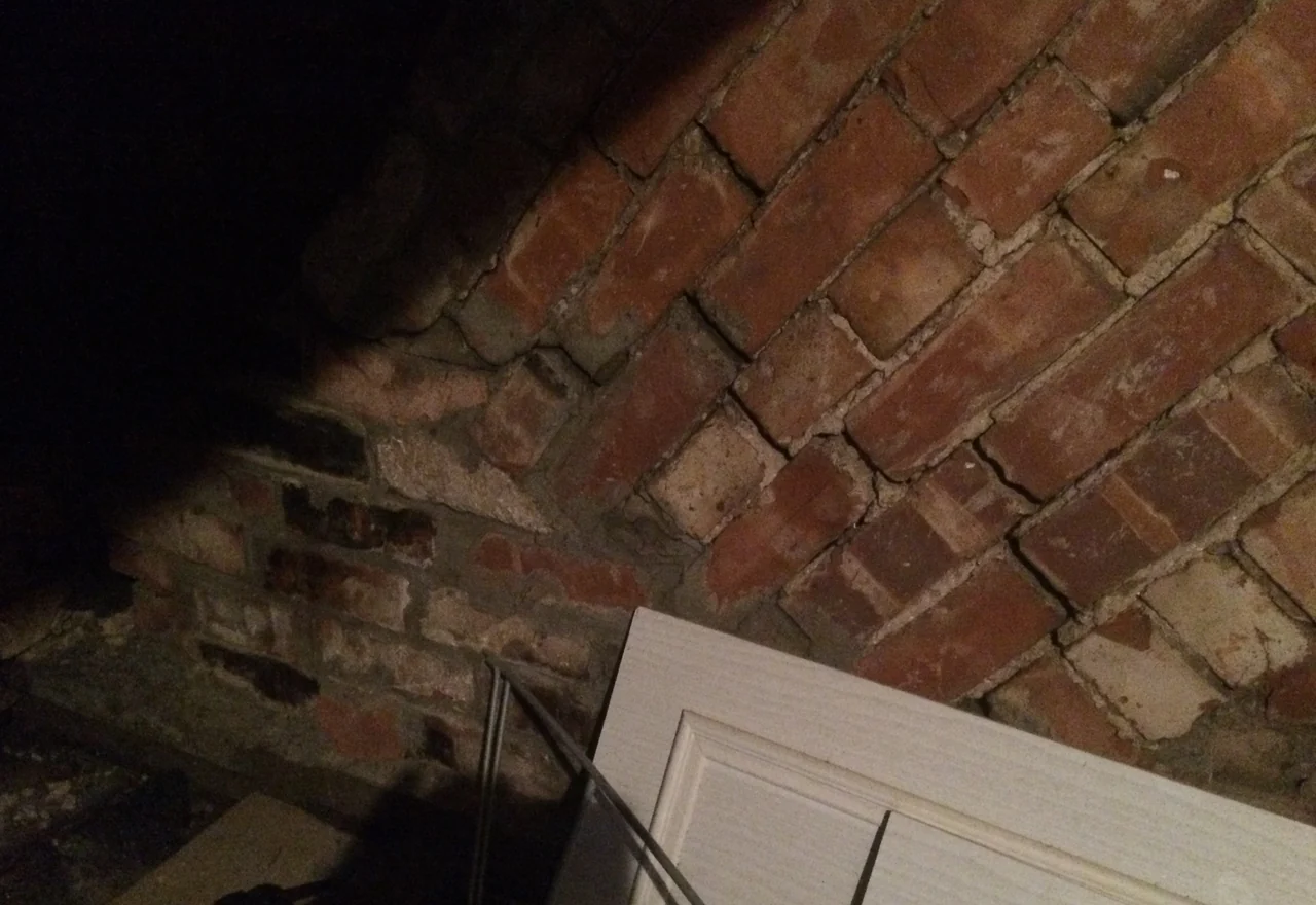Wider view of cracking in retained chimney breast masonry within the roof space in Cheadle Hulme