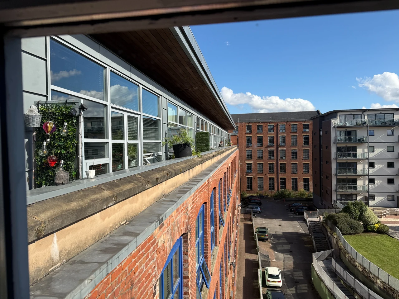 Cladding panels and glazing to the upper extension above the original brick building in Manchester