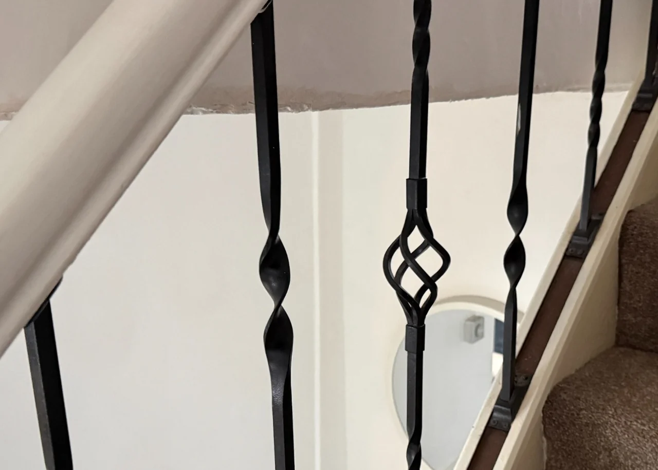 Wide gaps between metal staircase balustrade spindles in Marple