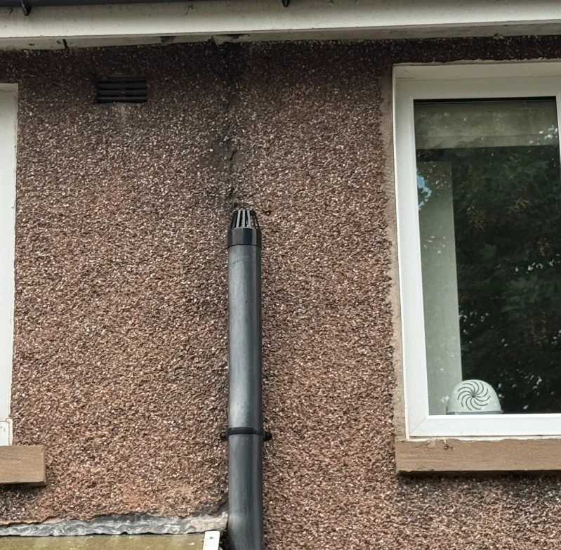 Shortened soil vent pipe terminating beside first-floor windows in Marple