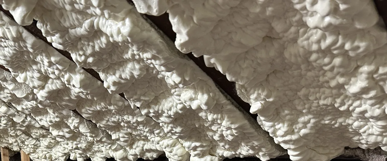 Spray foam coating between timber roof rafters