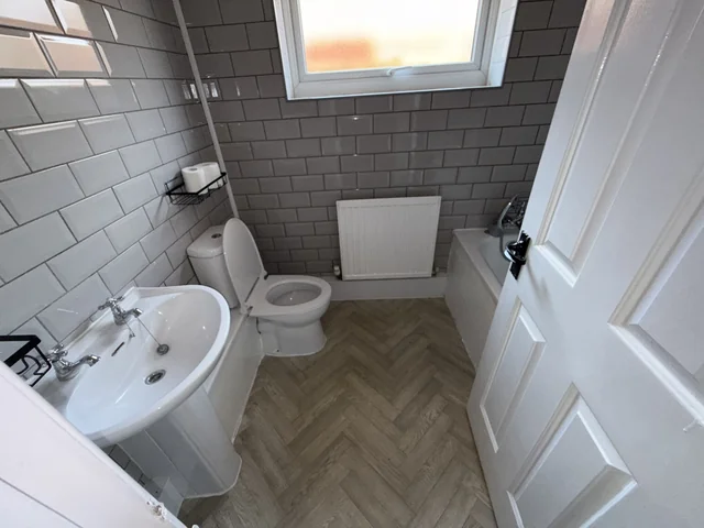 Bathroom with sanitary fittings, tiled surfaces and a window