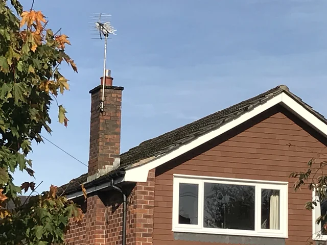 Brick chimney stack and its junction with a tiled pitched roof