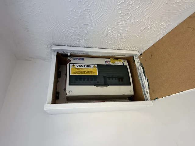 Electrical consumer unit viewed through its open cupboard door