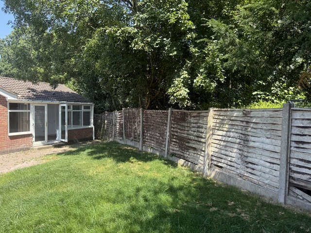 Garden lawn, planted boundary and timber fence