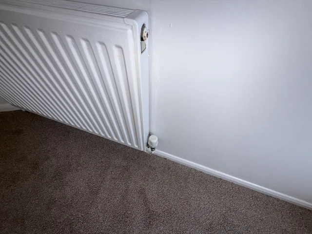 Panel radiator, valve and adjoining internal wall