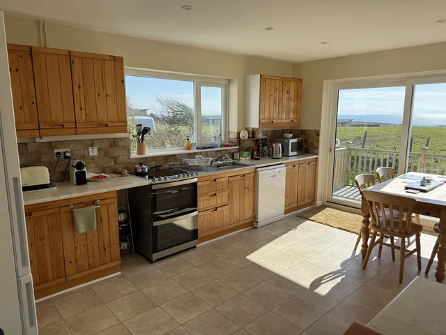Kitchen with fitted units, work surfaces and a dining area