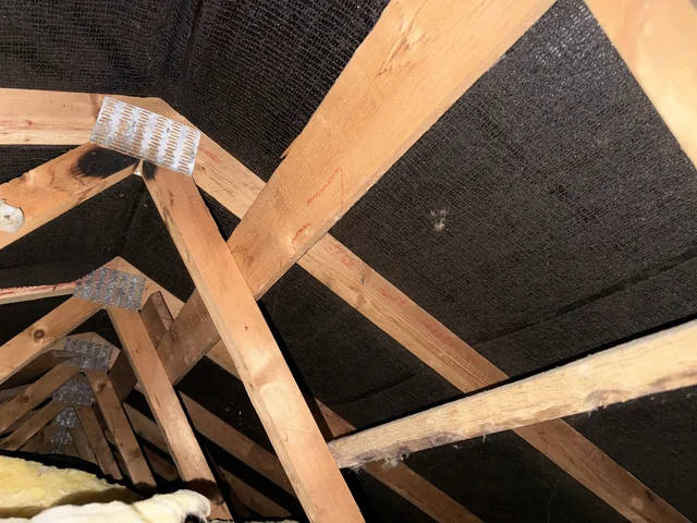 Timber roof trusses, metal connector plates and the roof underlay