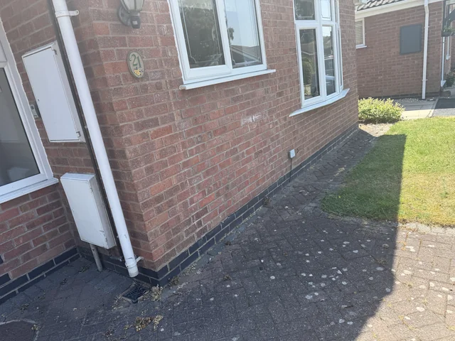 Brick wall, wall base and adjoining paved ground