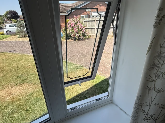 An open window viewed from inside beside the frame and sill