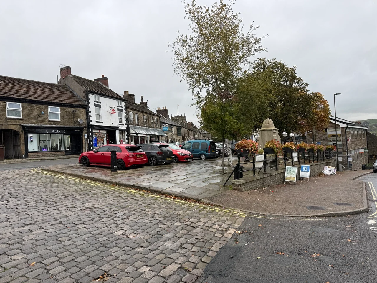 Cobbled square, memorial and stone buildings in Chapel-en-le-Frith