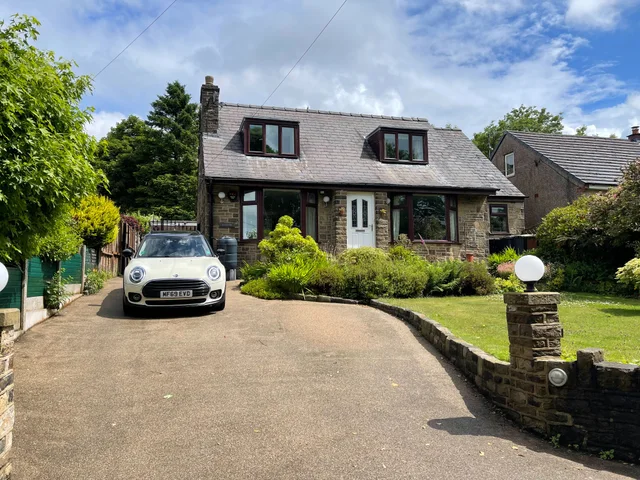 Stone-built house with dormer windows and a front garden