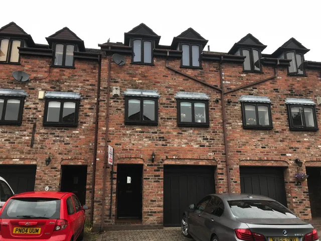 Brick townhouses with dormer windows and integral garages