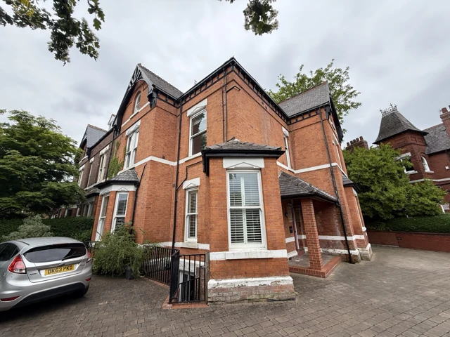 Older red-brick property with bay windows and decorative roof details