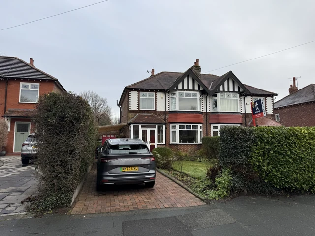 Brick semi-detached house with bay windows and a pitched roof