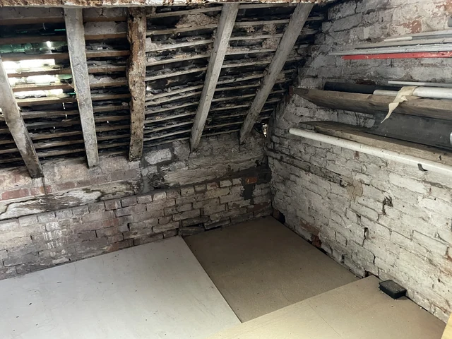 Traditional roof timbers, roof covering and masonry viewed from inside a roof space