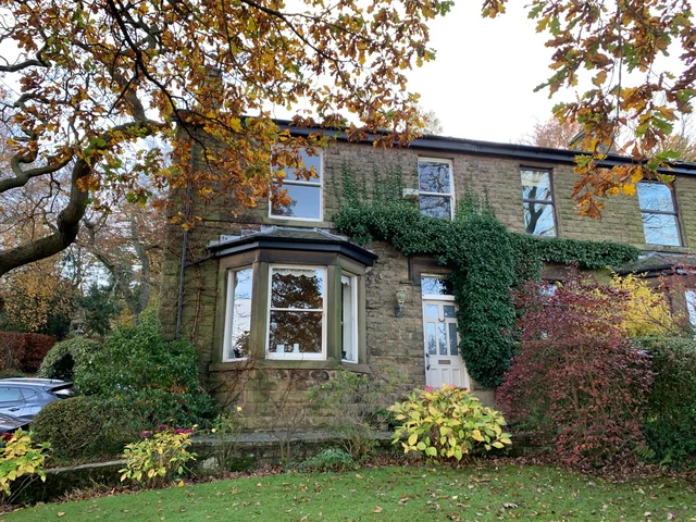 Stone cottage with a bay window and climbing plants in Mellor
